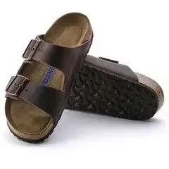 Et par brune Birkenstock sandaler på en hvid baggrund.