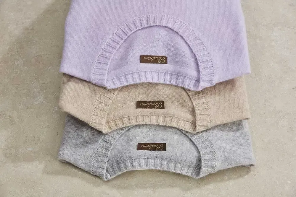 Tre trøjer er stablet oven på hinanden på et bord.