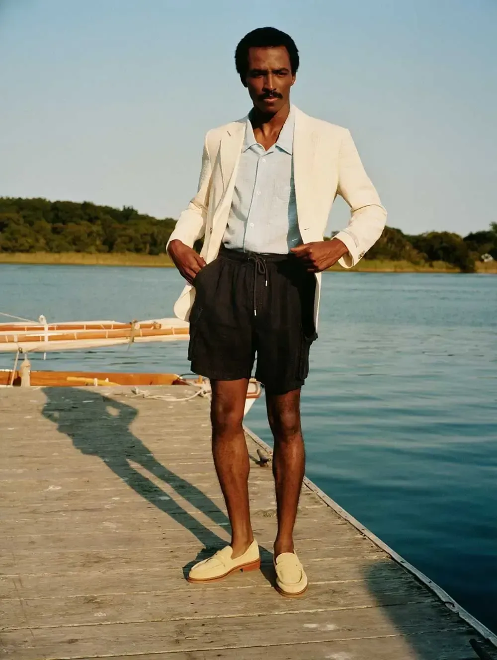 En mand står på en mole ved siden af et vandløb.