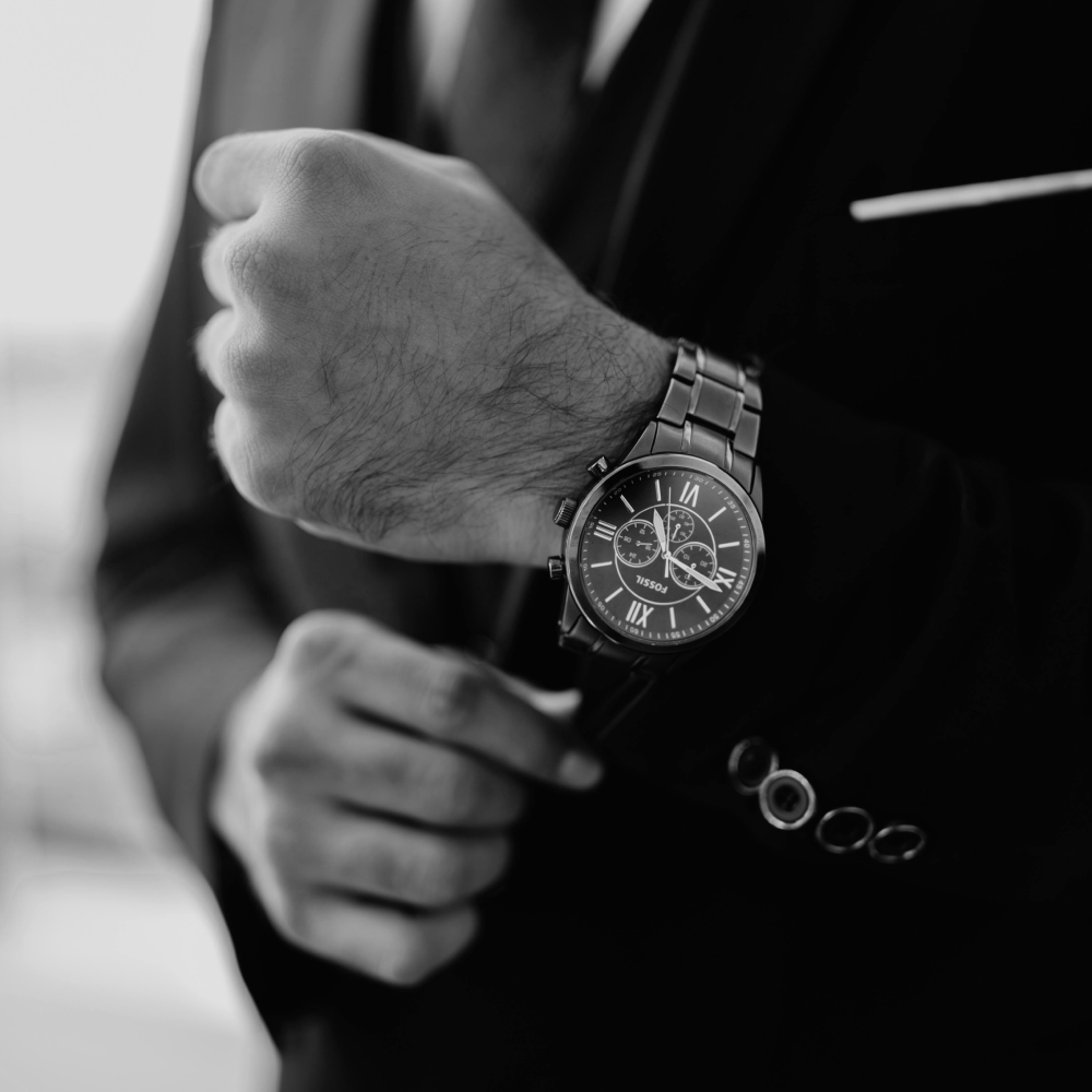 Silver wristwatch with a black face and chronograph features.