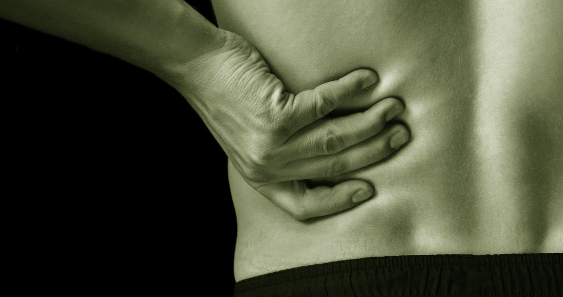 A person in pain grabbing their back