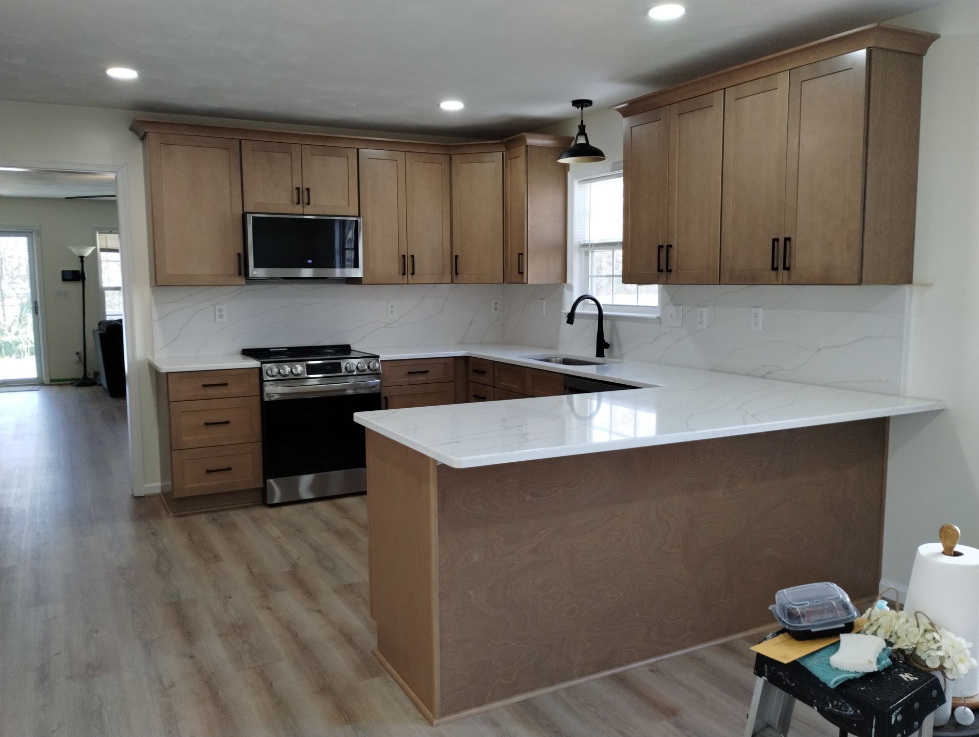 Newly renovated kitchen with light wood cabinets, white countertops, and stainless steel appliances.