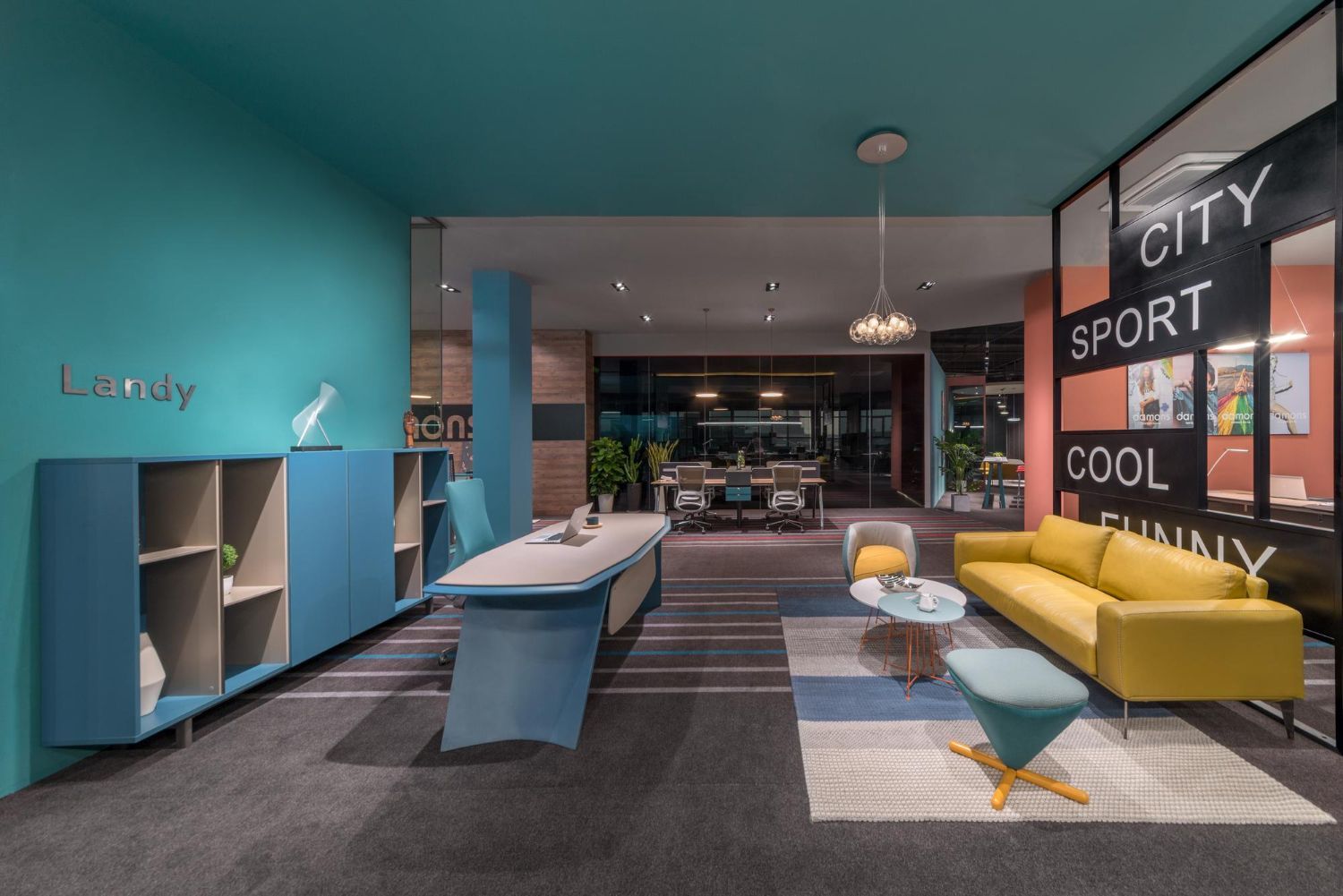 Modern office interior with blue and yellow furniture, teal walls, and a grey rug.