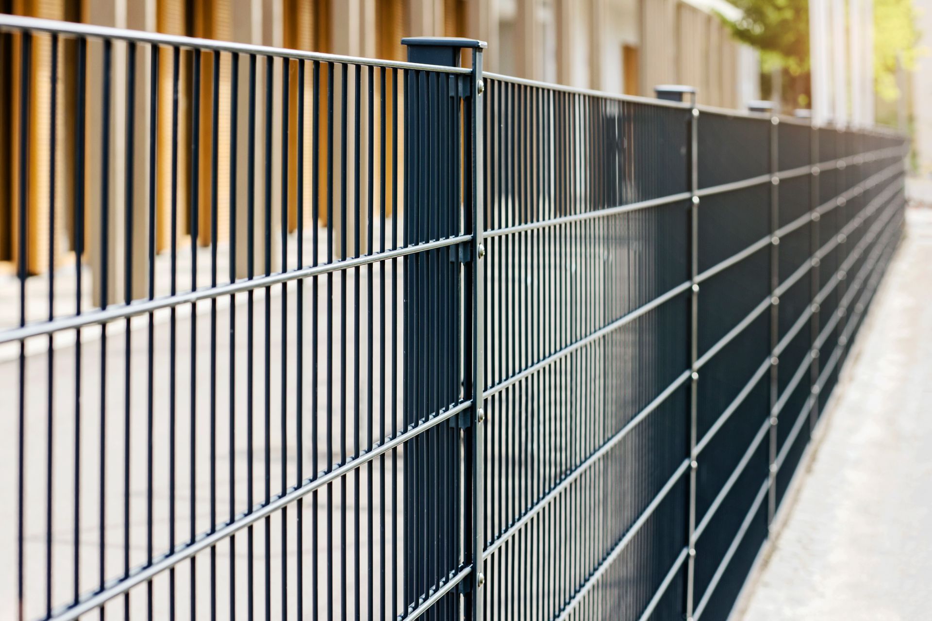 A close up of a metal fence in front of a building.
