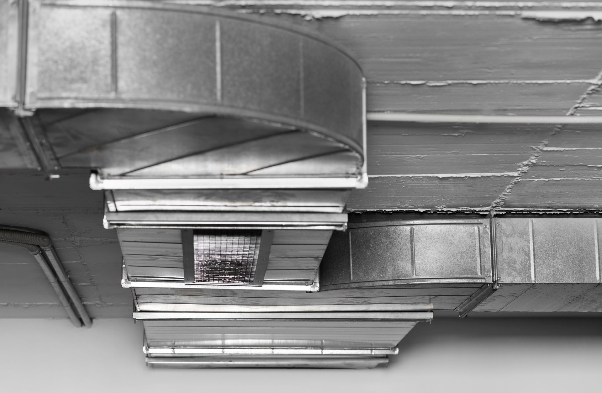 A black and white photo of a ventilation system in a building.