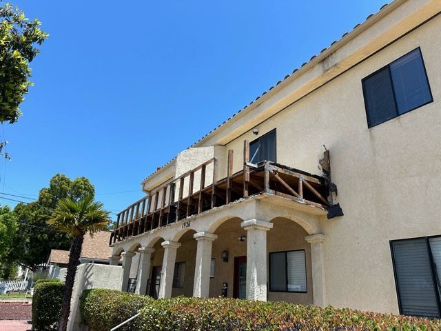 A building with a balcony and a blue sky in the background
