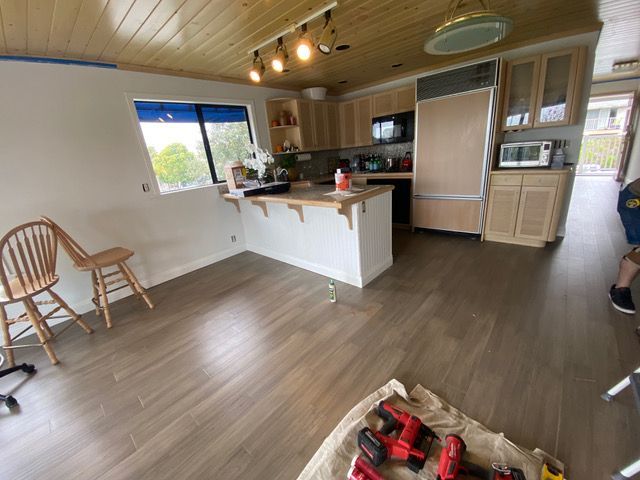 A kitchen with wooden cabinets and a wooden floor.