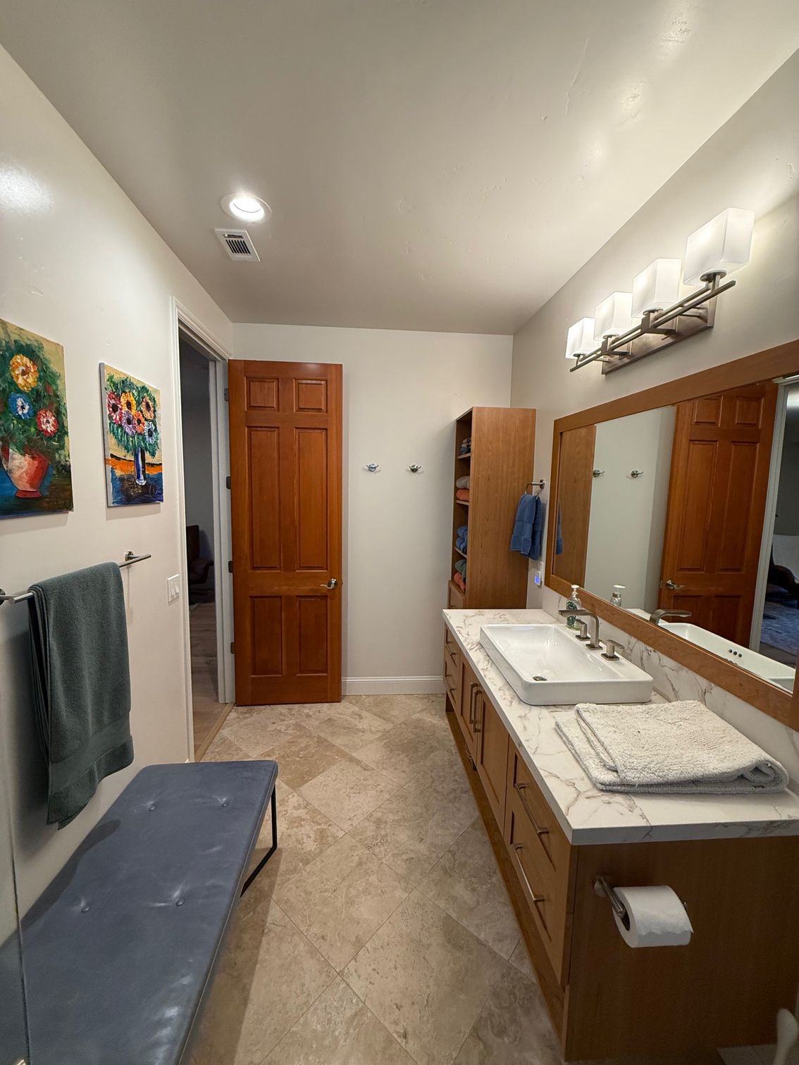 A bathroom with two sinks , a mirror and a bench.