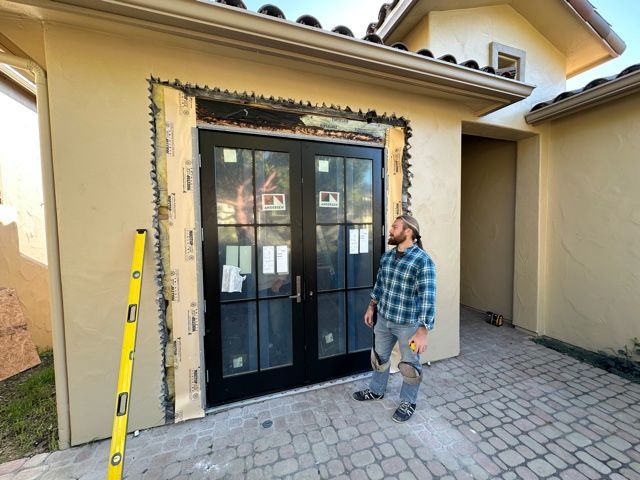 A man is standing in front of a building with a level.