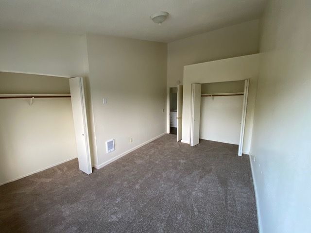 An empty bedroom with a large closet and a bathroom.