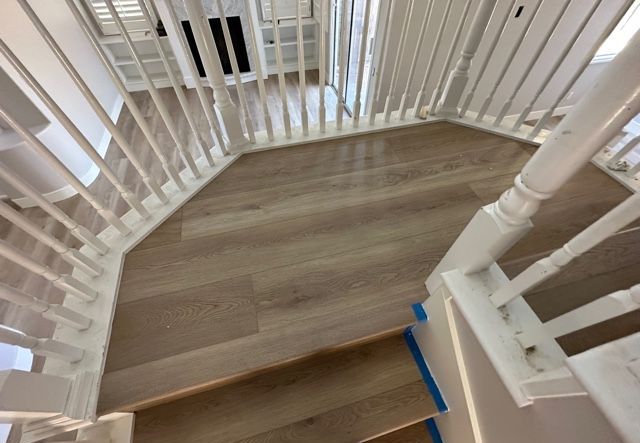 A staircase with a white railing and wooden steps in a house.