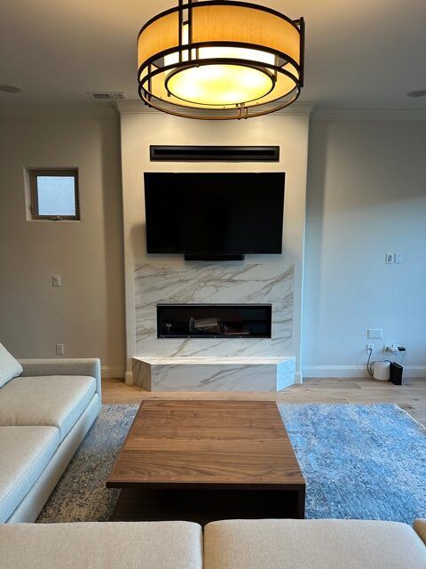 A living room with a fireplace and a flat screen tv