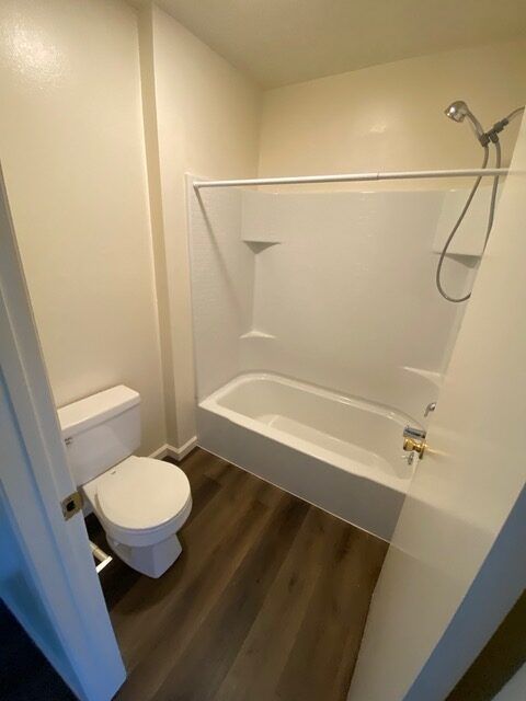 A bathroom with a toilet a bathtub and a shower