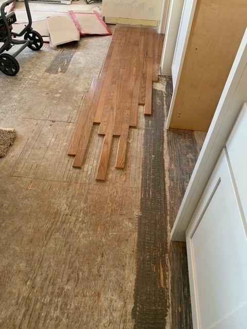 A wooden floor is being installed in a room.
