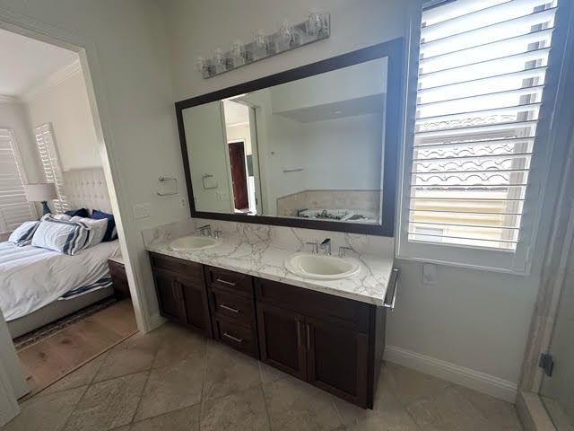 A bathroom with two sinks and a large mirror.