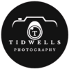 The logo for tidwells photography is a black circle with a camera in the middle.