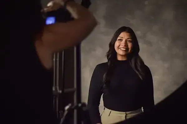 A woman is taking a picture of another woman in a photo studio.