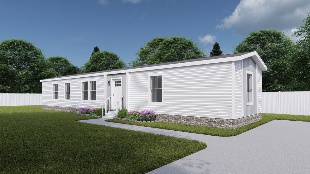 A white manufactured home with a gray stone foundation, front steps, and a driveway on a sunny day.