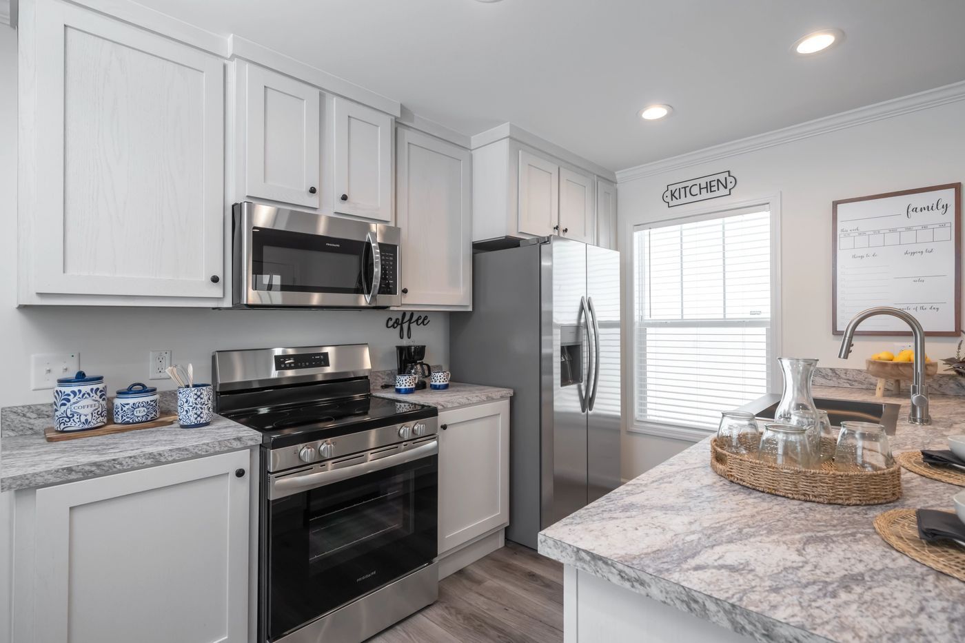 Modern kitchen with white cabinets, stainless steel appliances, and a gray countertop.