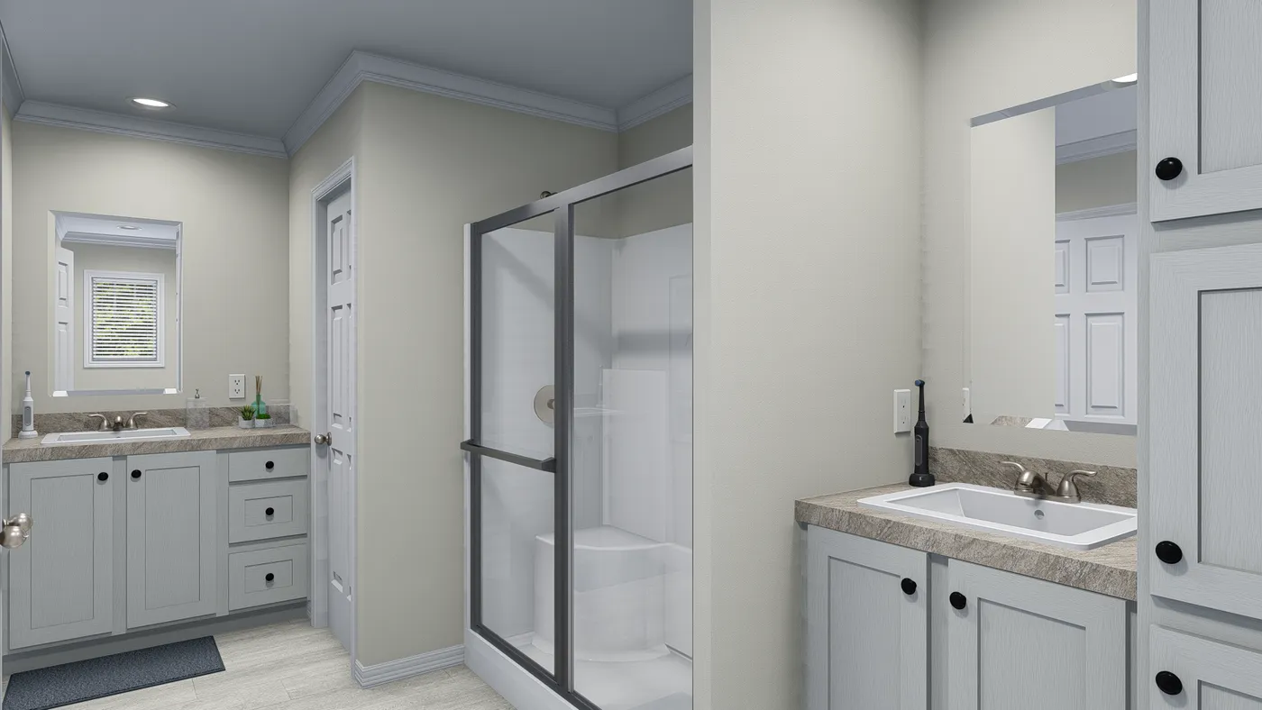Bathroom with light-colored walls, grey vanity, glass shower, and white fixtures.