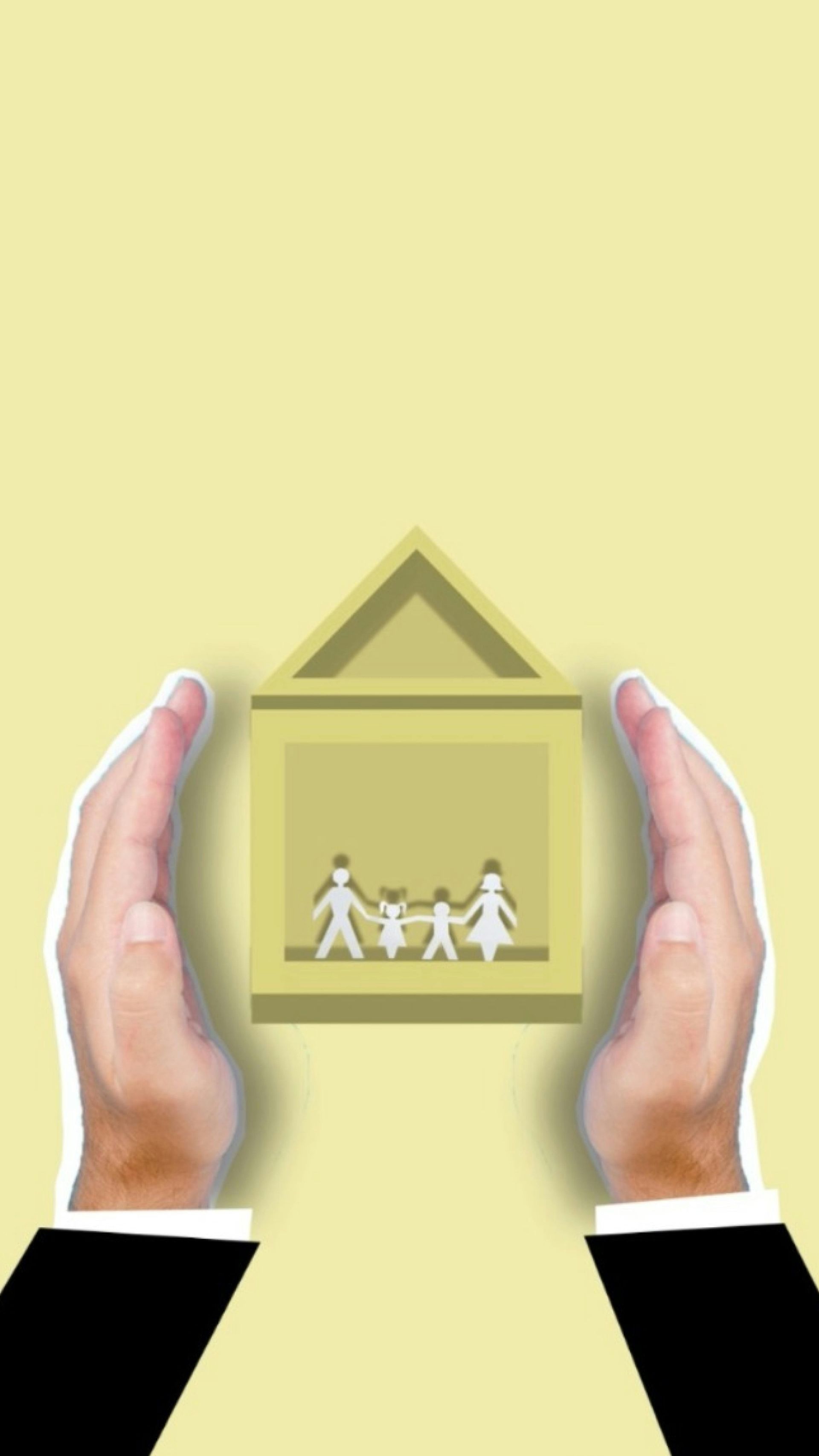 A person is holding a house with three people inside of it