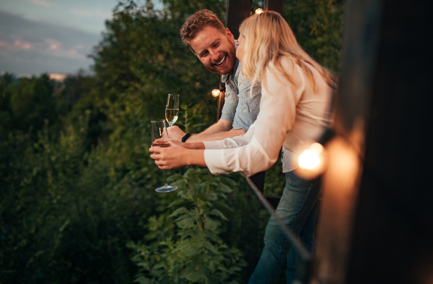 A man and a woman are standing next to each other holding glasses of champagne.