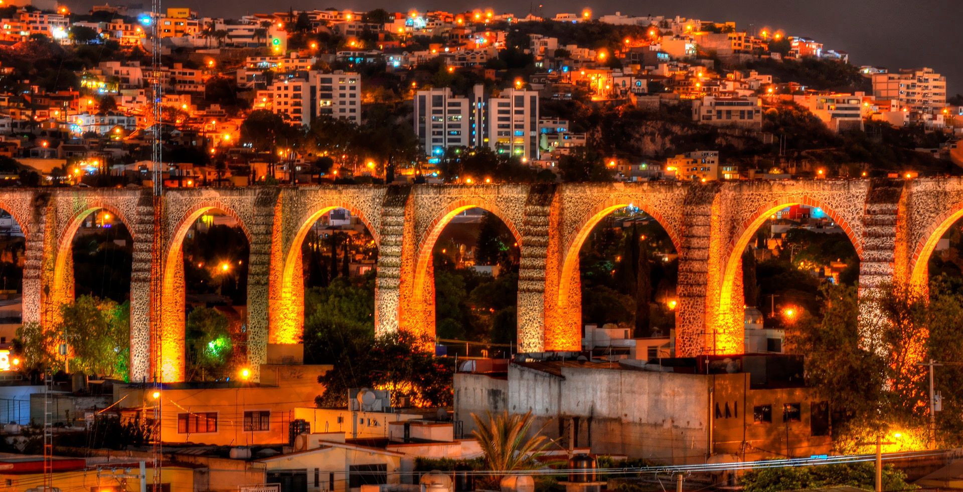 Coffee, toast, jam, and butter on a wooden table. A cozy breakfast scene with white plates and cups.