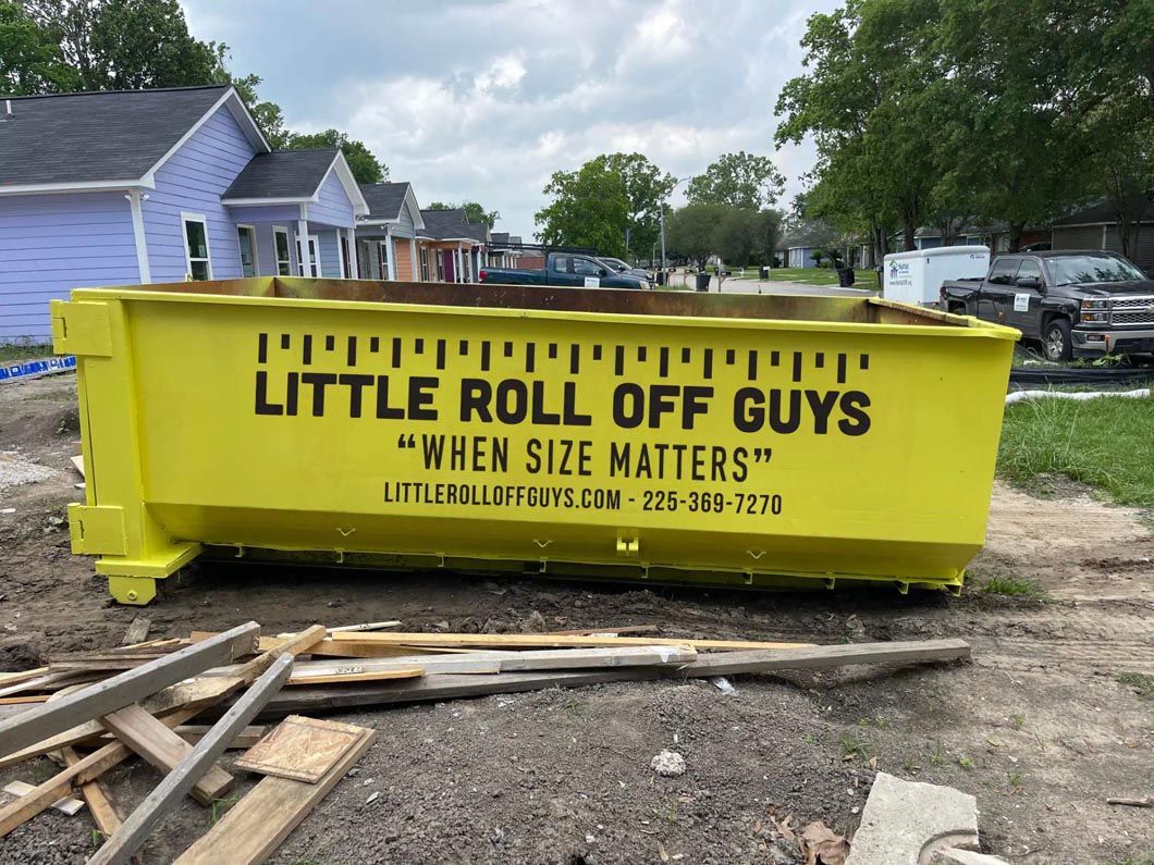 A yellow dumpster with the words `` little roll off guys '' written on it.