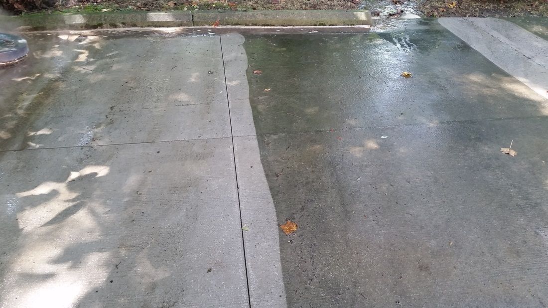 A split-view image showing a section of dirty concrete next to a section cleaned with a power washer.
