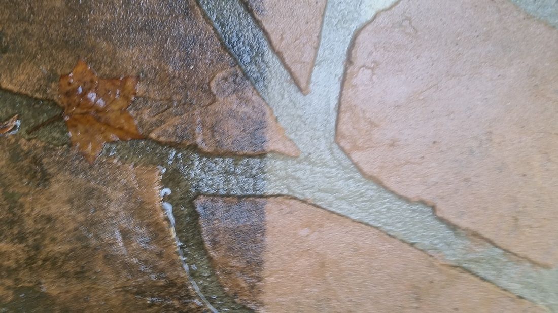 A split-view showing dark, dirty stone tiling on the left and clean, light-colored stone tiling on the right.