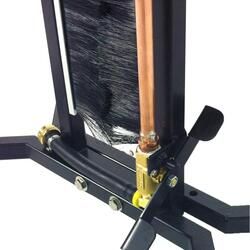 Close-up of a boot scraper and brush with a copper pipe and brass valve for water cleaning.