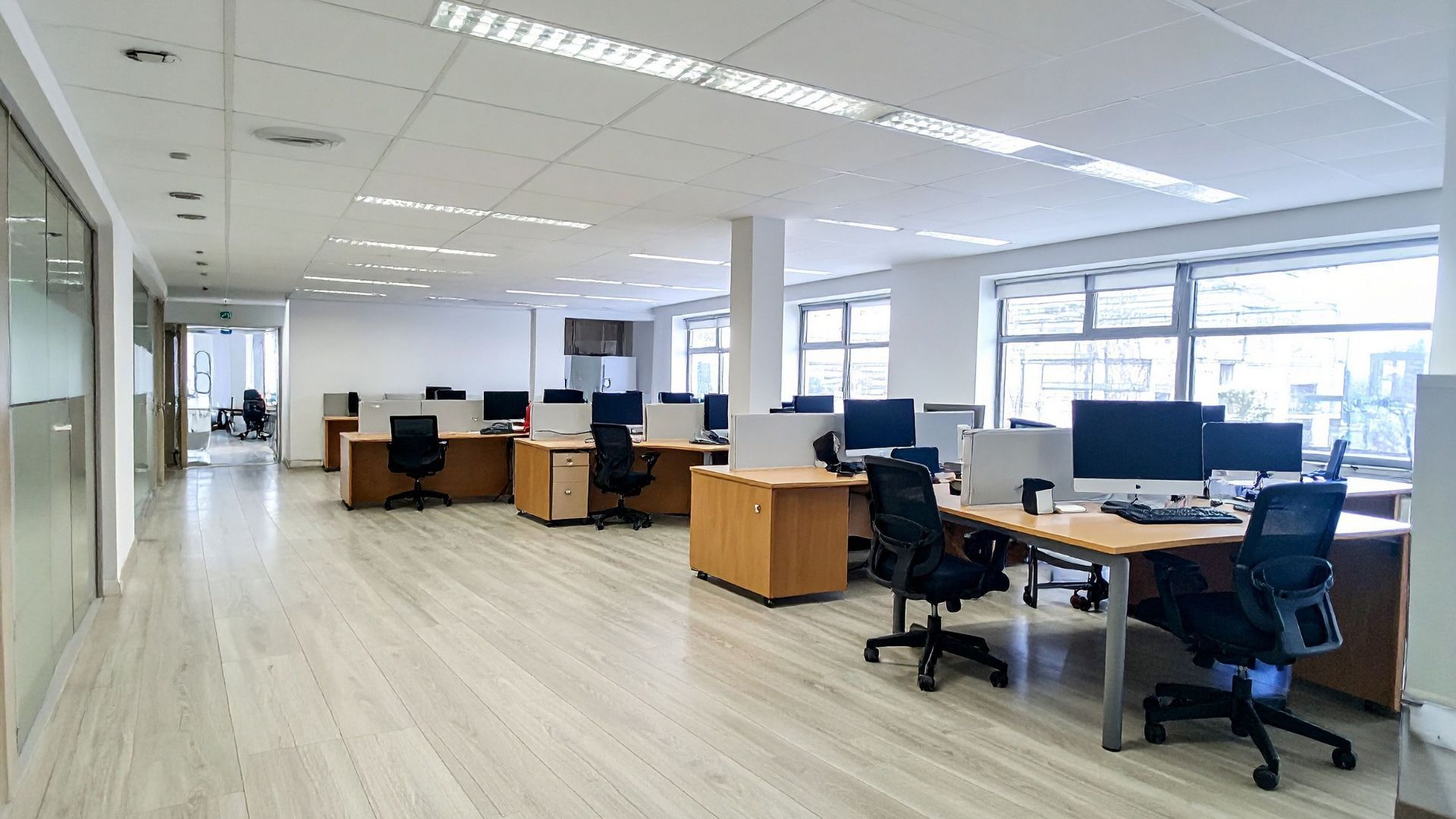 Conference room with long table, chairs, and large windows overlooking a scenic view.