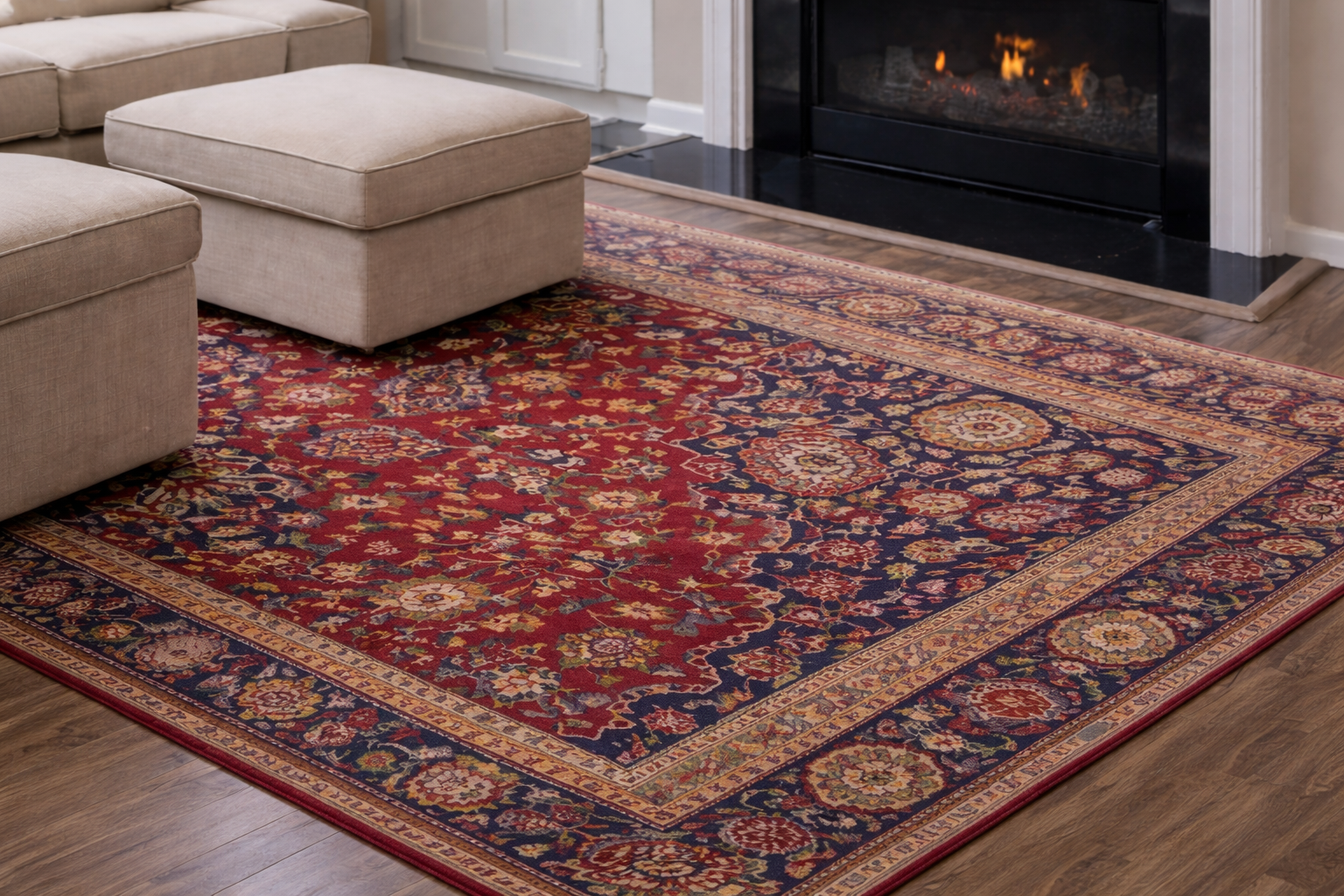 Red and navy patterned rug in a living room, with cream ottoman and fireplace.