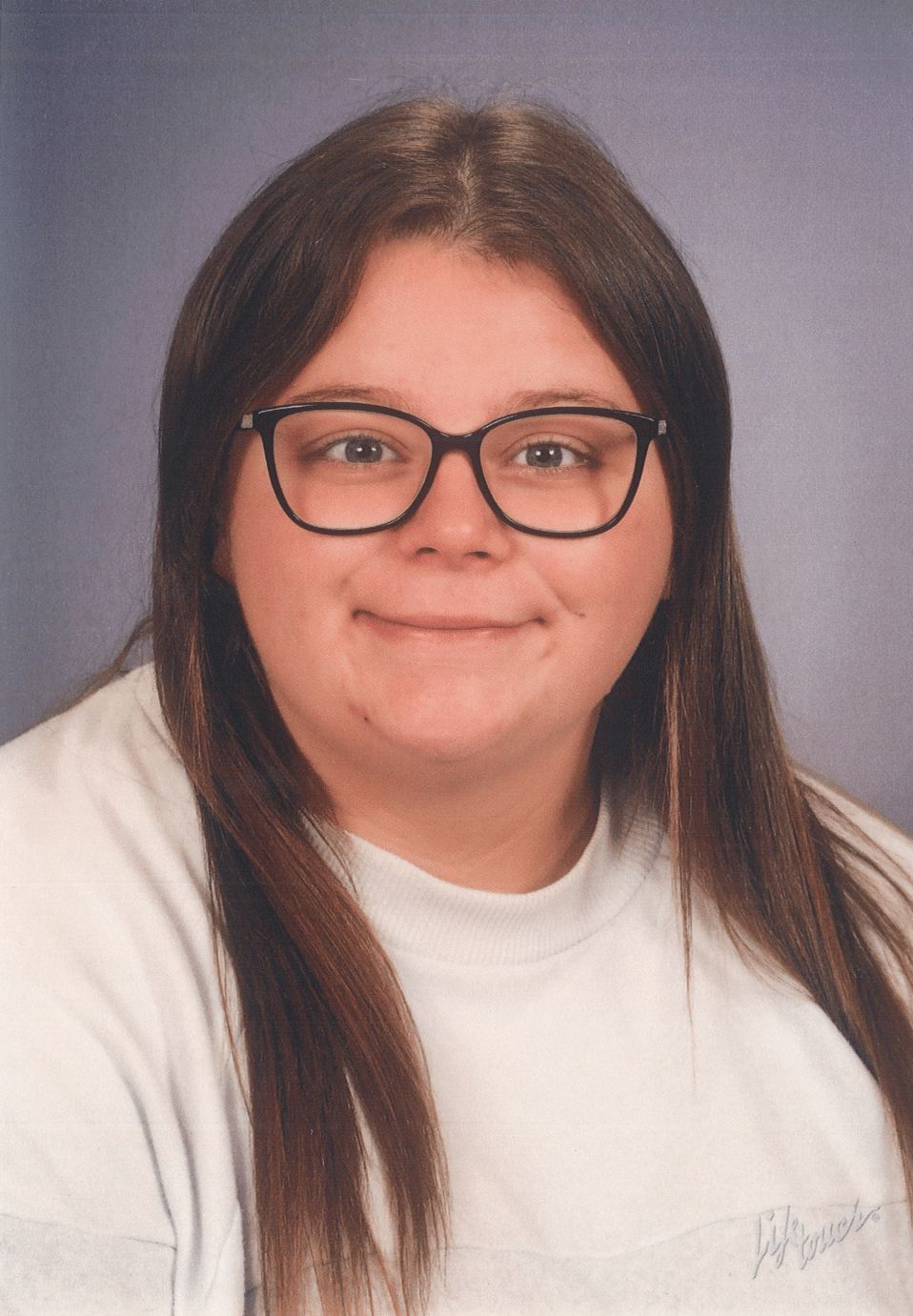 Person with glasses smiles; light-colored shirt; text beneath reads 