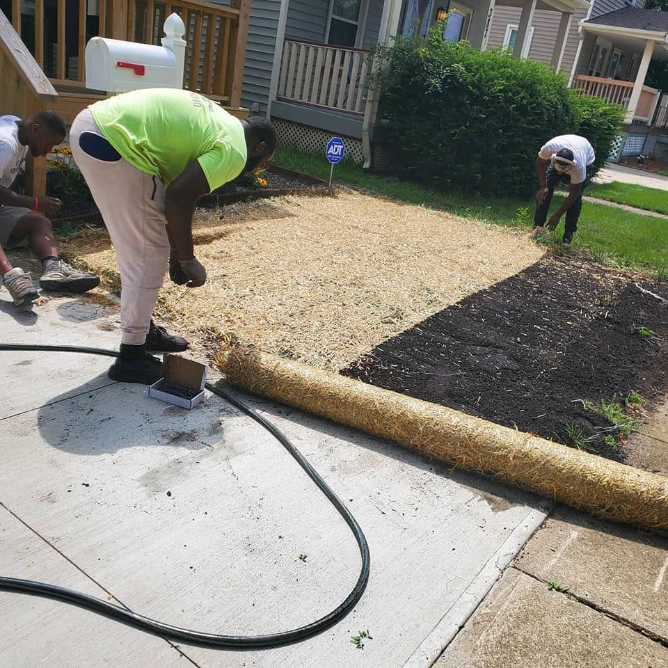A man in a neon green shirt is working on a lawn