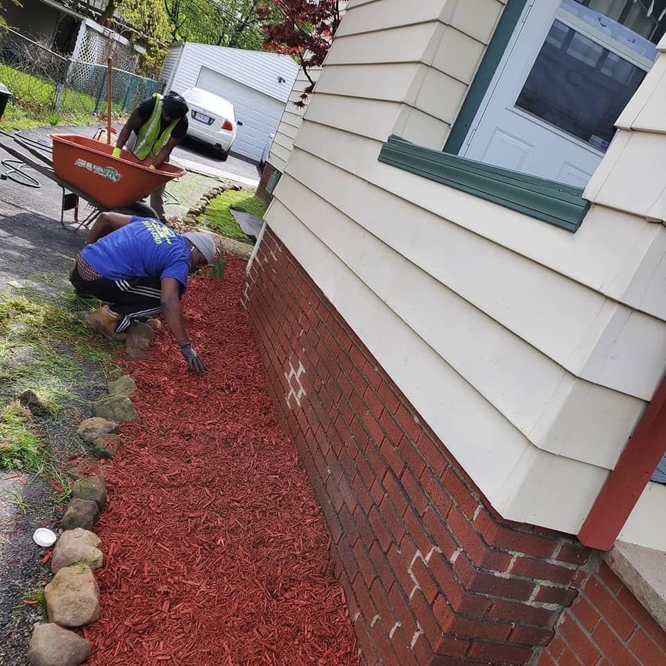 Two men are working on a sidewalk in front of a house.