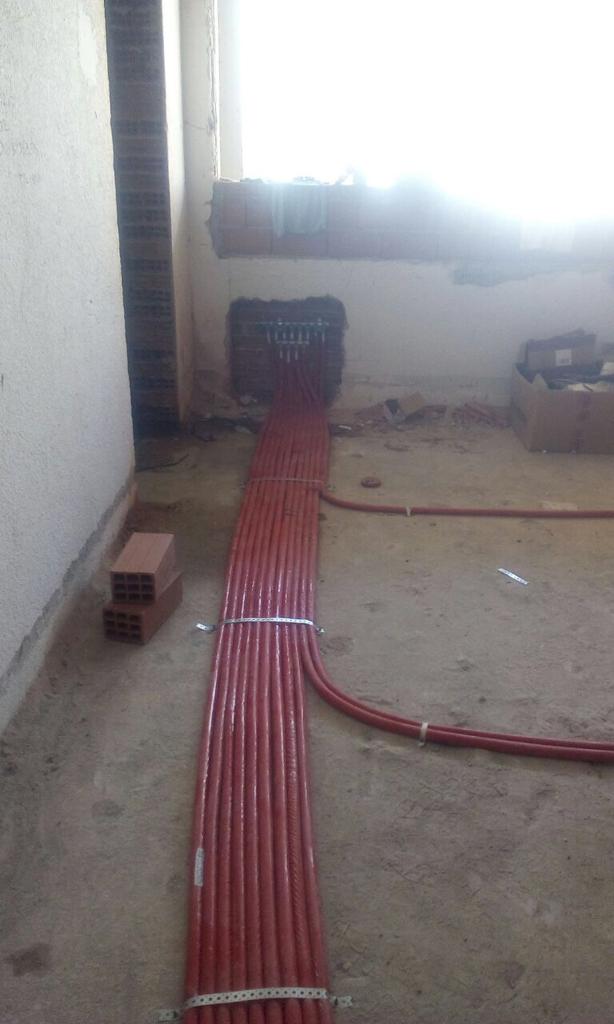 Un mucchio di fili rossi sono stesi sul pavimento di una stanza.