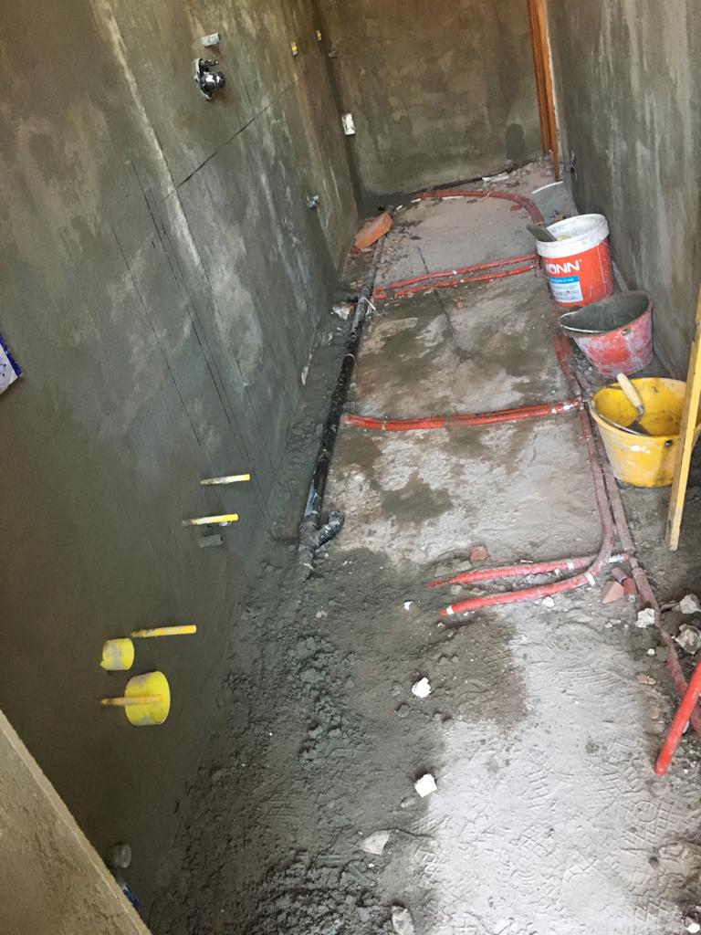 Un bagno in costruzione con secchi di cemento sul pavimento.