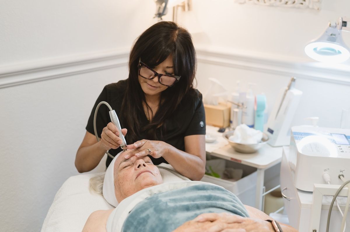 Monina using a hydroderm tool on a client