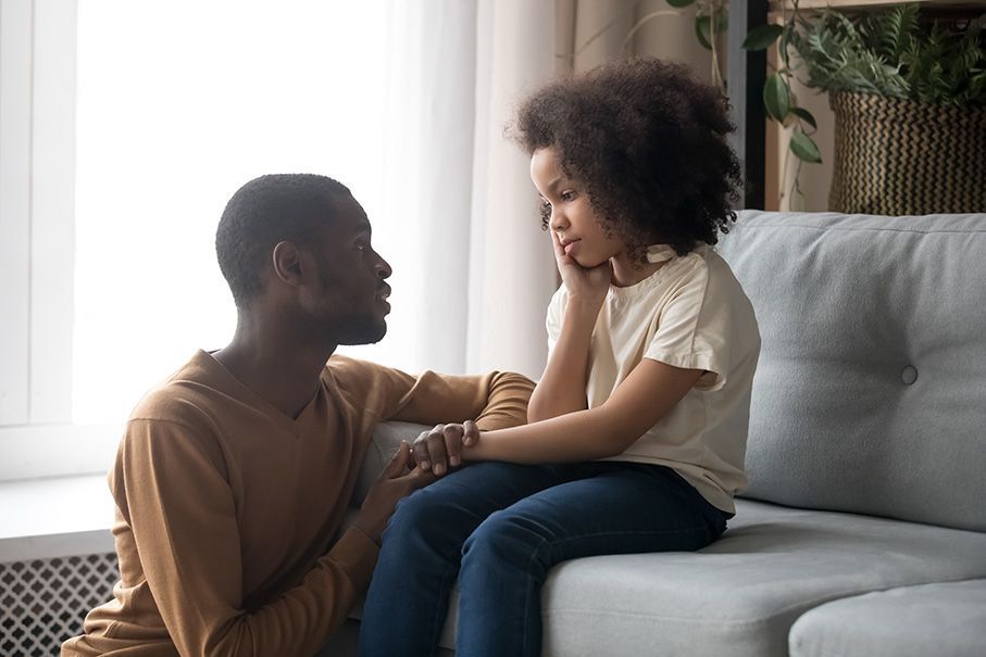 Sad African American little girl talking to dad about death