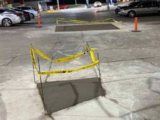 A concrete walkway is being built in a parking lot.