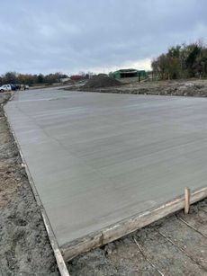 A concrete driveway is being built on a construction site.