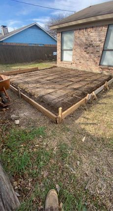 A brick house with a wheelbarrow in front of it is being built.