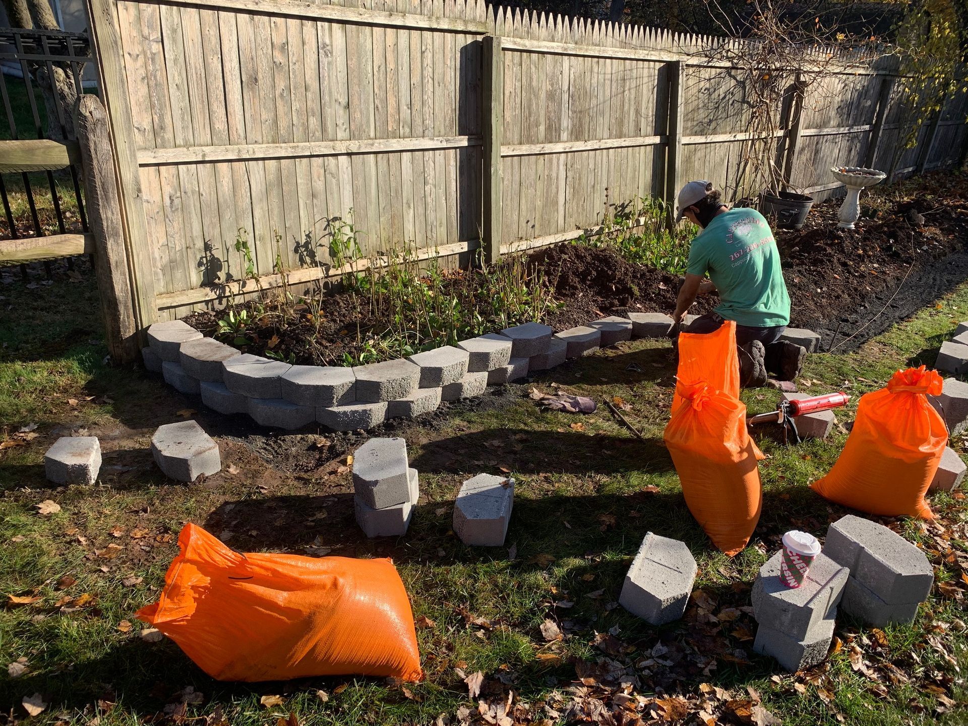 A Man is Laying Bricks in a Garden — Langhorne, PA — Cappuccino Land Services
