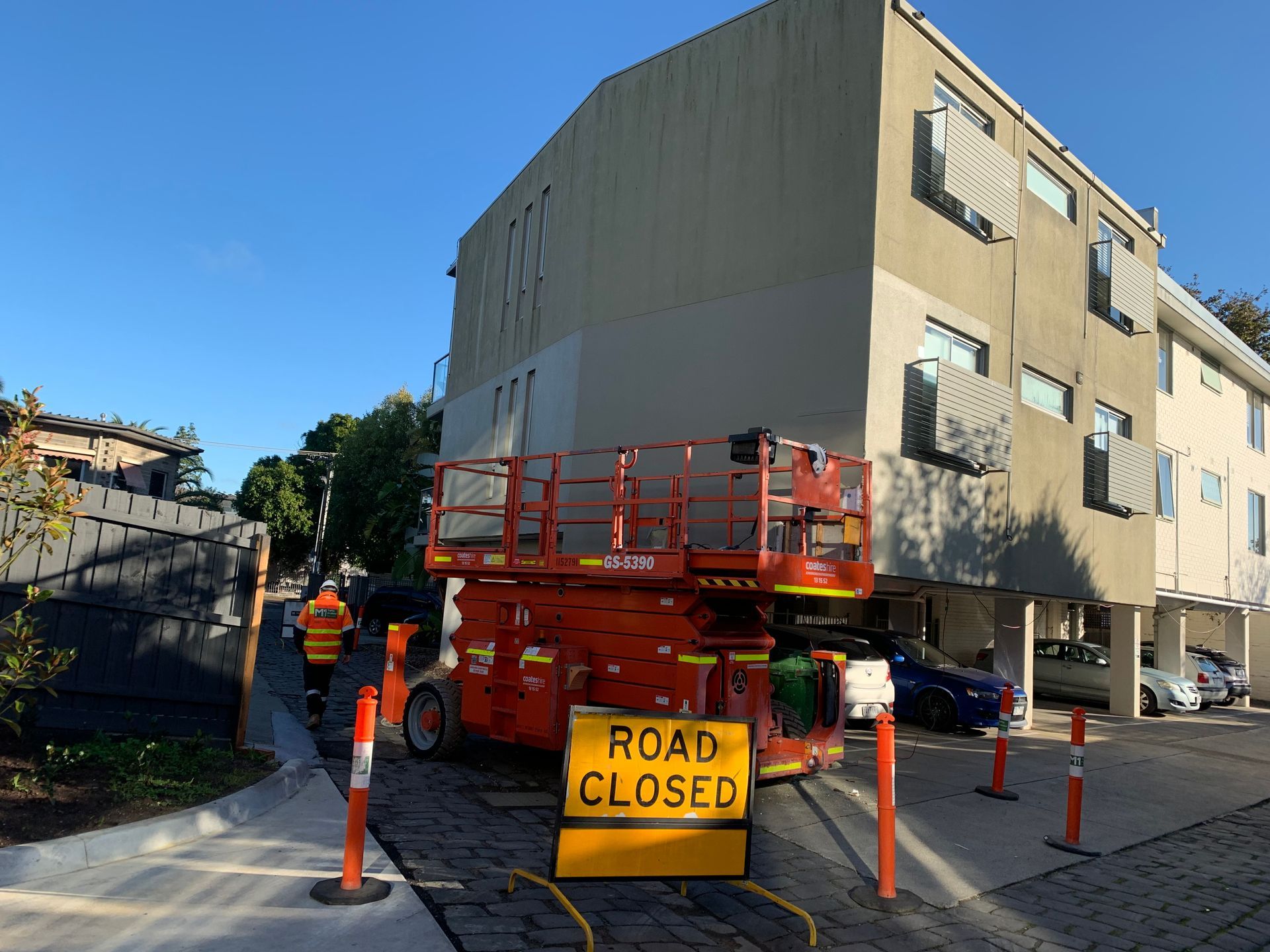 A yellow sign that says road closed is in front of a building