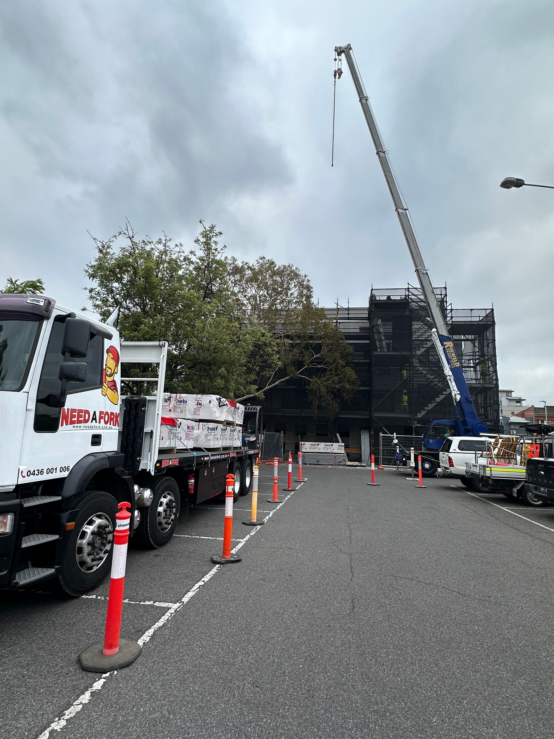 A construction site with trucks and a crane in the background