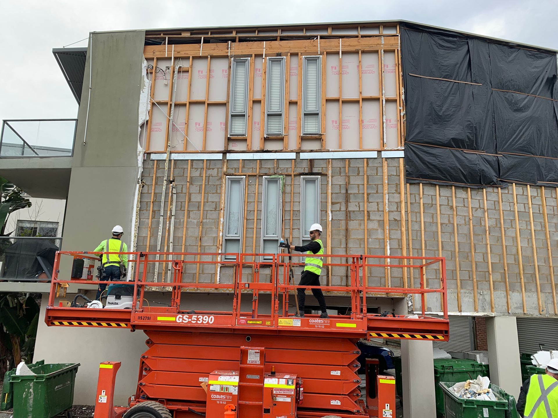 A group of construction workers are working on a building.