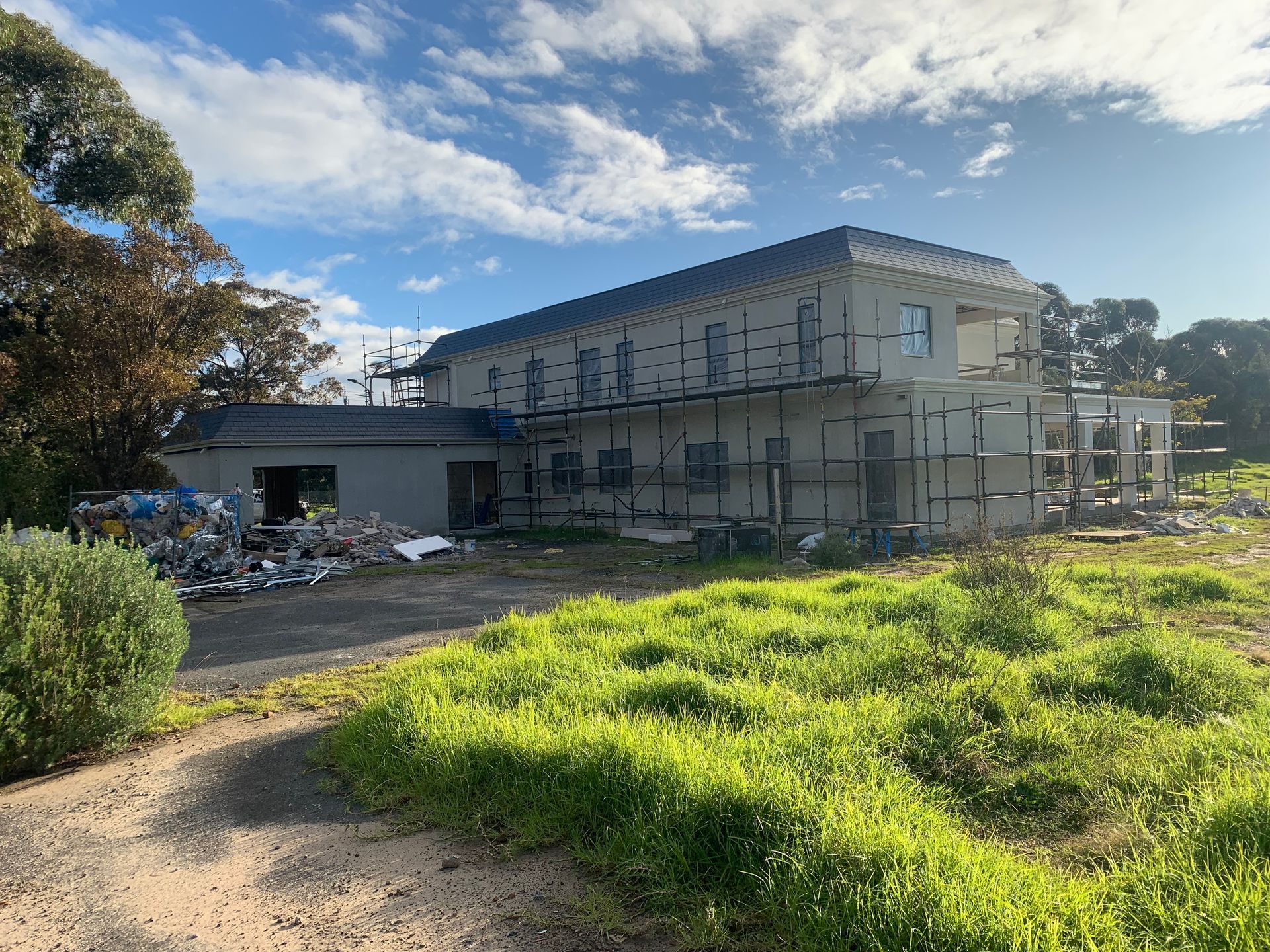 A large building is being built in a grassy field.