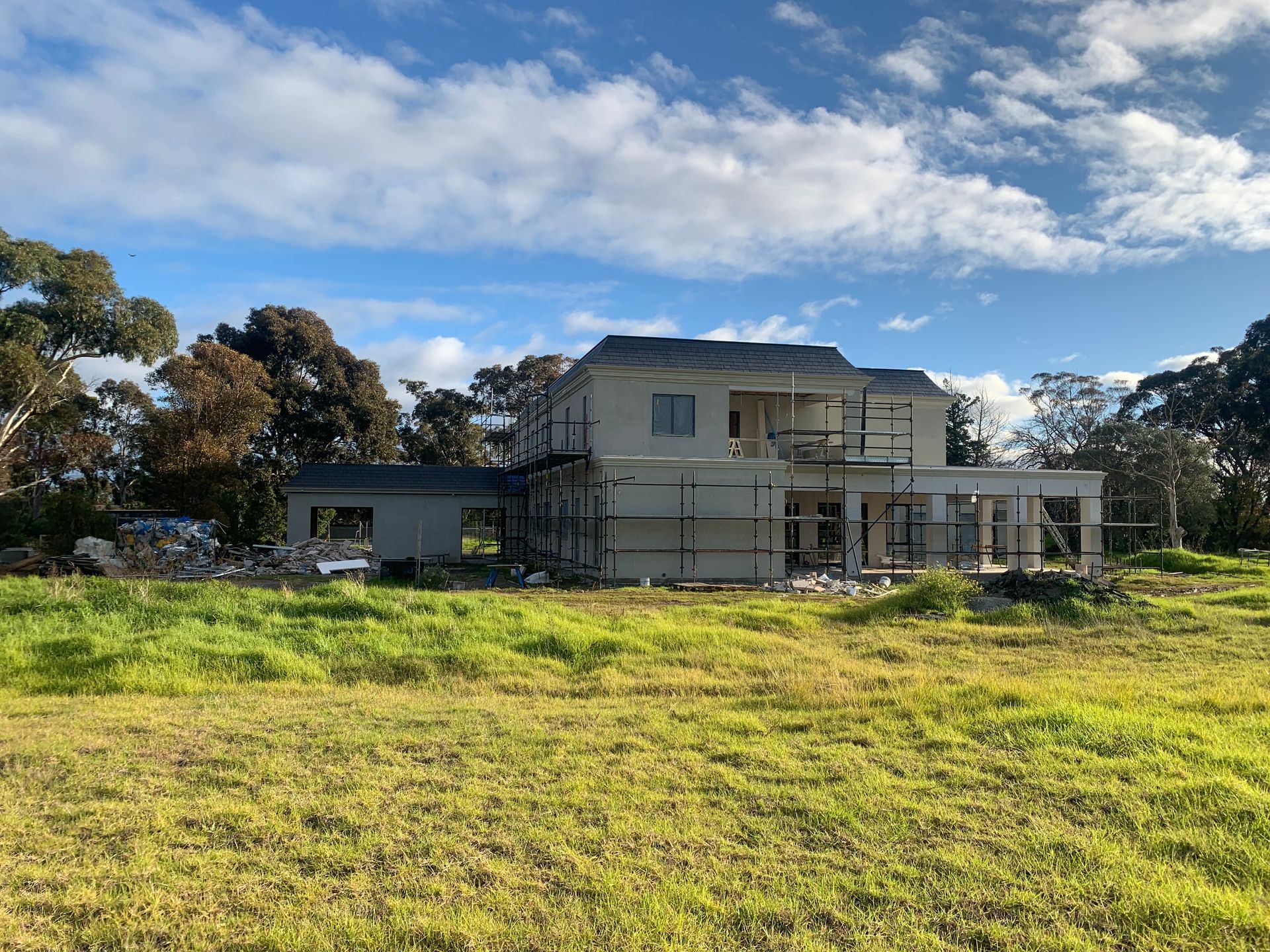 A house is being built in the middle of a grassy field.