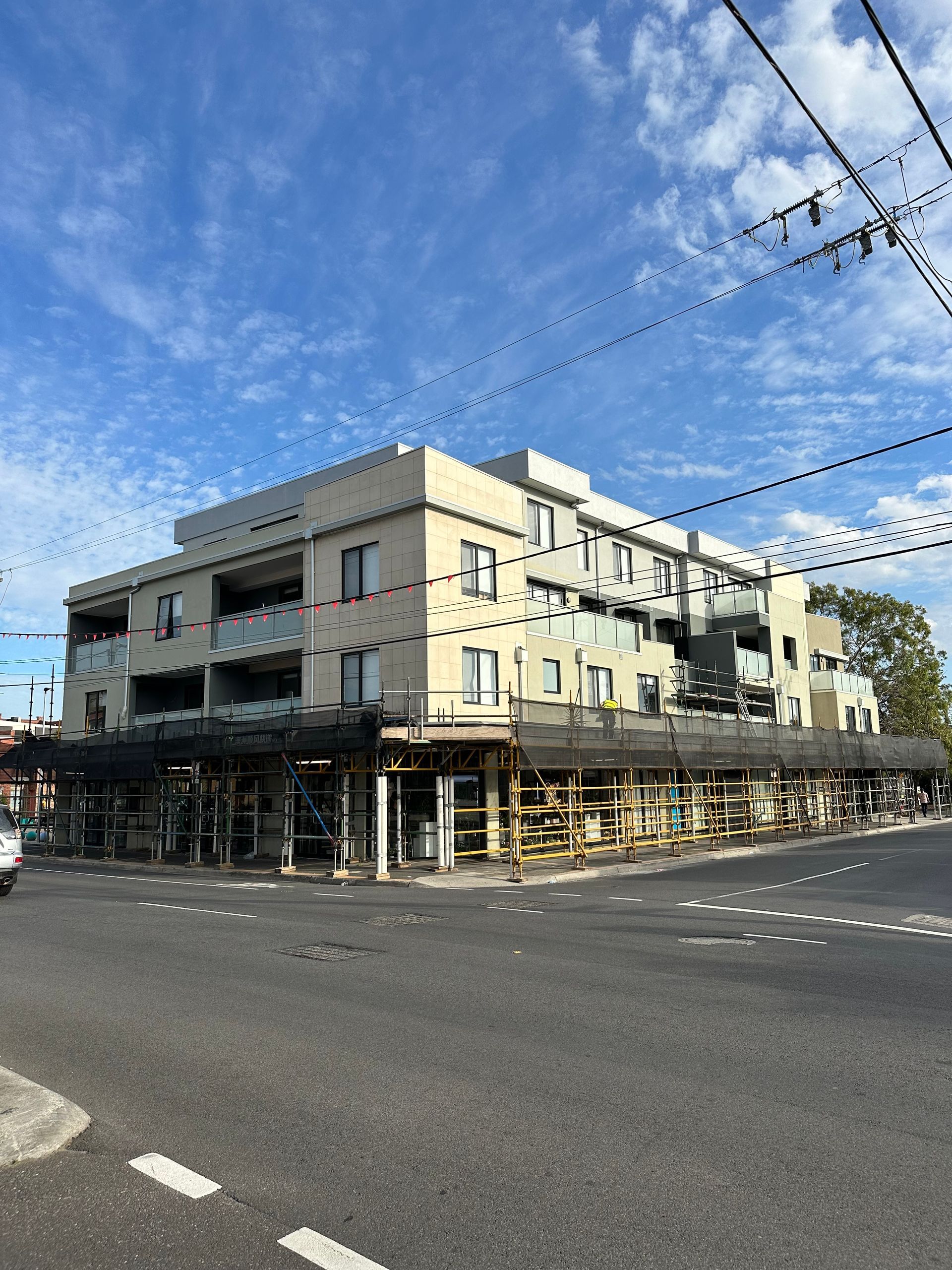 A large building is being built on the corner of a street.